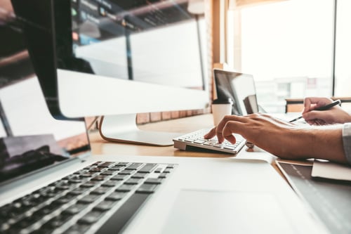 person at office typing on desktop computer
