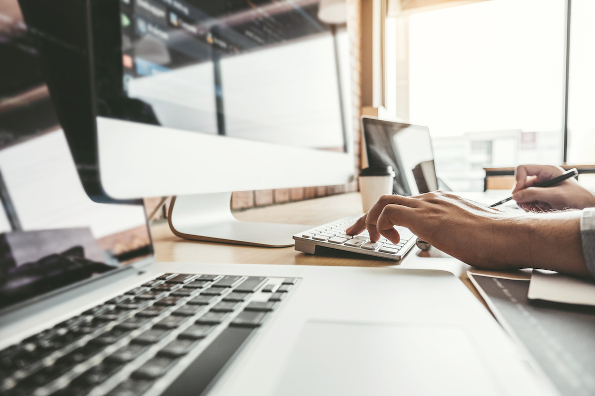 person at office typing on desktop computer