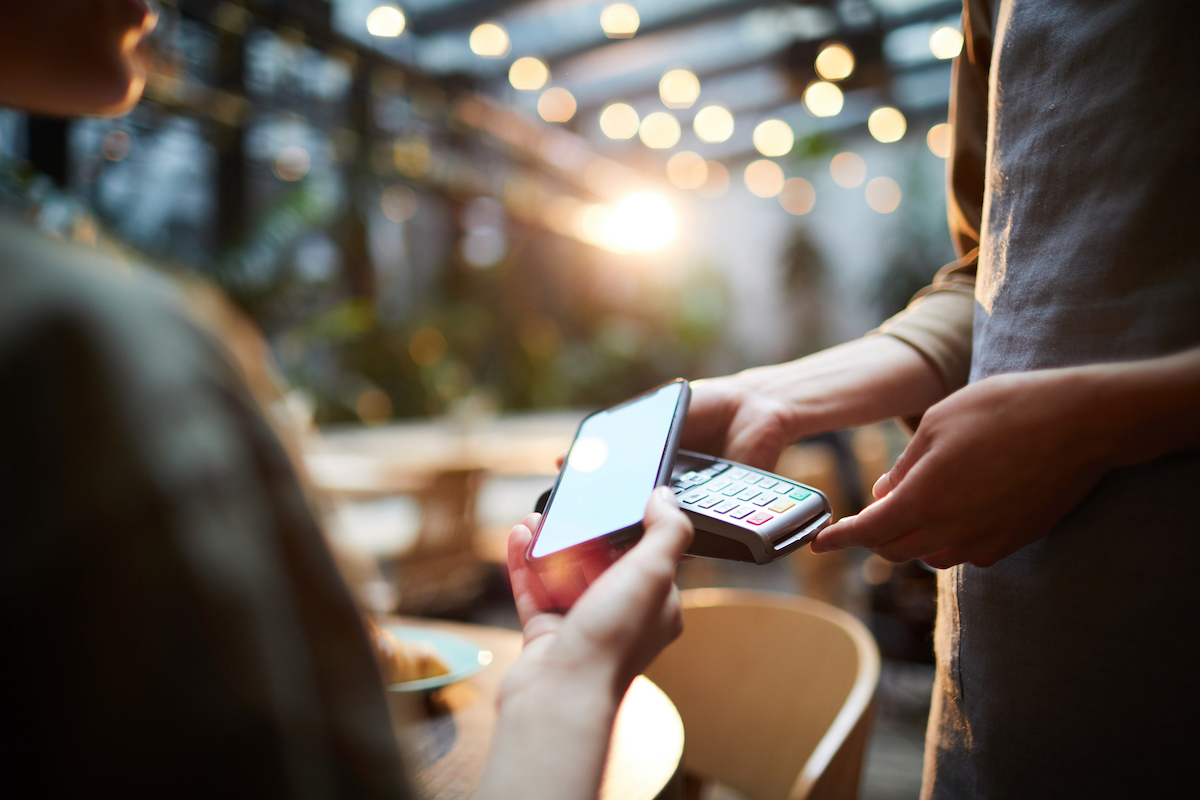 person paying with phone at restaurant